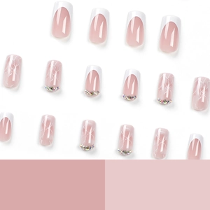 French tip press-on nails with nude base, white marble patterns, and glitter rhinestones