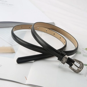 Detailed view of black slim leather belt featuring intricate silver engraved buckle and loop