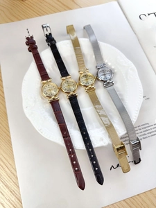 Selection of vintage quartz watches with leather and mesh bands on elegant tray