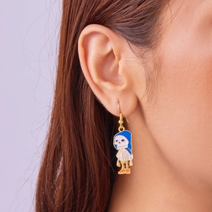 Detail shot of a skeleton earring with blue hood and orange shoes worn by a model