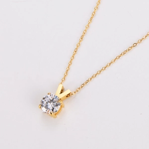 Detailed view of gold necklace with large round-cut sparkling zircon in 4-prong setting