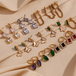 Macro view of assorted 18K gold and silver geometric earrings with colorful zircons