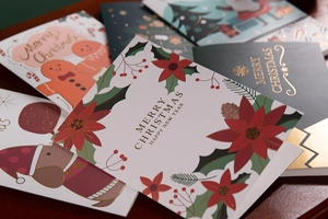 Macro shot of assorted Christmas cards with gold foil patterns and festive messages