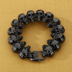 Close-up of gothic skull link bracelet with glossy black finish and heavy metal clasp