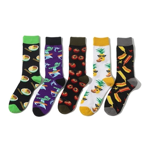 Flat lay of five pairs of crew socks featuring tomato, pineapple, and alien patterns