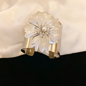 Detail of silver floral cuff bracelet featuring a large 3D petal and pearl centerpiece