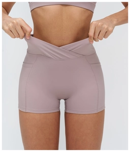 Detail of high waist yoga shorts featuring a V-shaped crossover waistband and side pockets