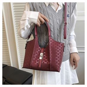 Detailed close-up of wine red monogram tote bag with gold buckle and adjustable strap
