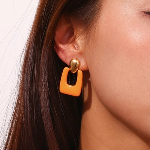 Close-up of model wearing orange hollow rectangle drop earrings with 18K gold waterdrop stud