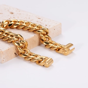 Polished gold Cuban link chain for men on stone texture background, hip hop style jewelry