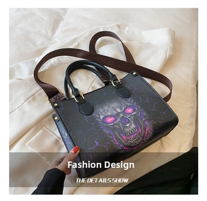 Close-up of skull print tote bag with purple accents and adjustable brown shoulder strap