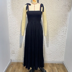 Detail of black tiered sundress with bow shoulder straps and smocked bodice on mannequin