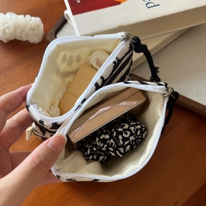 Detail showing the double-layer interior of a zebra print canvas mini storage pouch