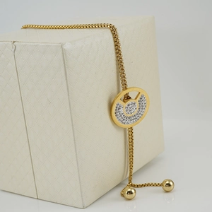 Gold plated titanium steel sweater necklace with round rhinestone pendant on a jewelry box