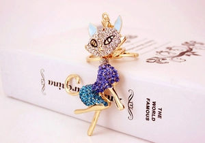 Close-up of golden cat keychain with blue rhinestones on a book background