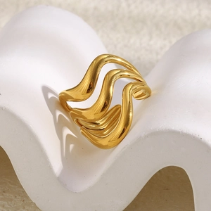 Detailed view of gold triple-layered wave ring on a white minimalist display stand