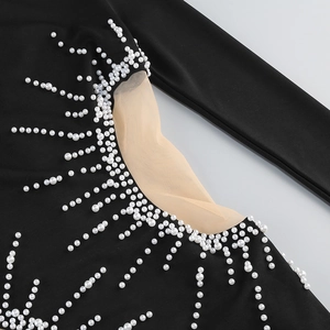 Détail d'une robe noire avec perles artificielles blanches et découpes en mesh ajouré