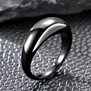 Macro shot of minimalist black titanium steel teardrop ring on textured leather background