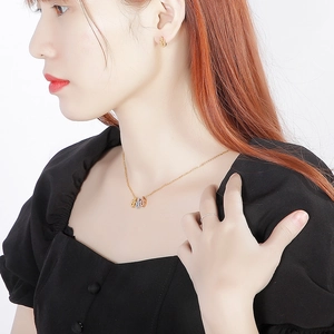 Detailed close-up of a model wearing a geometric gold necklace and earring jewelry set