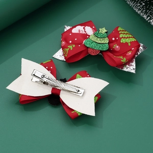 Detail view of Christmas handmade fabric bow hair clips with glitter trees and duckbill clips