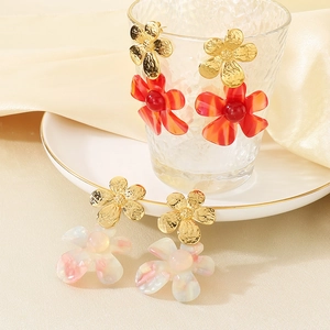 Detailed shot of retro 18k gold plated flower earrings in red and white resin petals