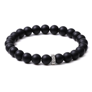 Close-up of matte black agate beaded bracelet featuring a geometric silver spacer bead