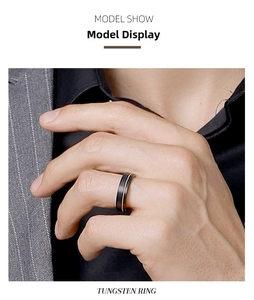 Close-up of a brushed black tungsten ring with silver edge on a male model hand