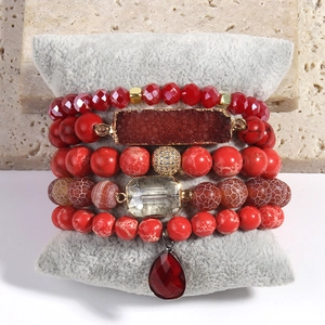 Detail of bohemian stackable bracelet set with red natural stones and faceted beads