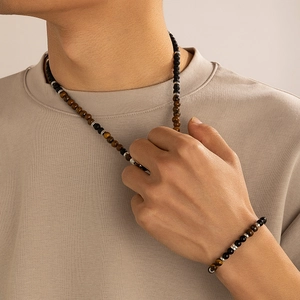 Dettaglio del set da uomo con collana e bracciale in pietra lavica e occhio di tigre