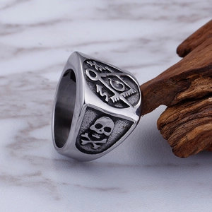 Macro shot of vintage Masonic steel ring featuring skull motifs on wood and marble