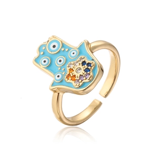 Macro detail of Hamsa ring with blue enamel Evil Eye and sparkling colorful rhinestones