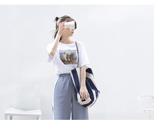 Detail of canvas tote bag with dark blue and beige stripes on minimalist outfit