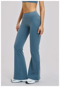 Vertical full view of high-waisted flared yoga pants in dusty blue on a professional model