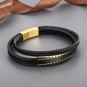 Détail d'un bracelet multi-rangs en cuir pour homme avec fermoir magnétique doré et tressage