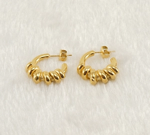 Détail des boucles d'oreilles torsadées en forme de C plaquées or 18 carats sur peluche