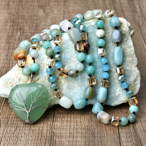 Macro detail of heart-shaped green aventurine pendant with wire-wrapped tree of life
