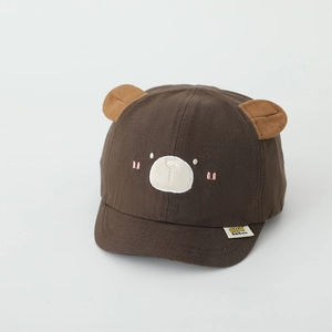 Détail de casquette enfant avec oreilles d'ours 3D et visage brodé marron sur le devant