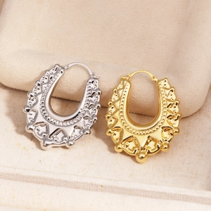 Detalle de pendientes en forma de U de oro y plata con relieve en estuche de terciopelo