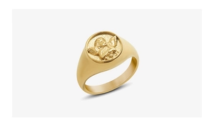 Detail of golden ring with angel relief carving and brushed metal surface finish
