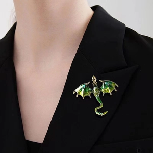 Vintage green enamel dragon brooch pinned on a black suit jacket lapel for men