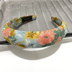 Close-up of bohemian wide headband with colorful floral print and handmade label