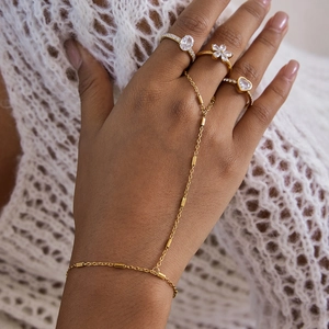 Bracelet esclave doré avec bagues en zircon et motifs de fleurs et de cœurs sur main