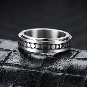 Close-up of rotatable stainless steel moon phase ring on black crocodile texture leather