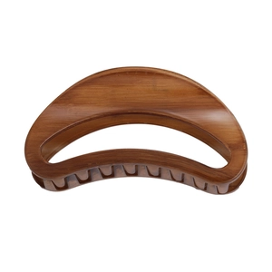 Detailed view of the large crescent hair claw clip featuring a brown faux wood grain pattern