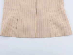 Détail de l'ourlet rayé kaki et de la fente sur cette jupe de style anglais