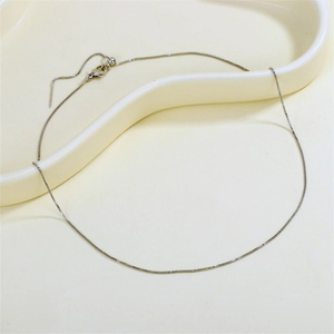 Adjustable silver box chain necklace with needle pin and slider bead on ceramic tray