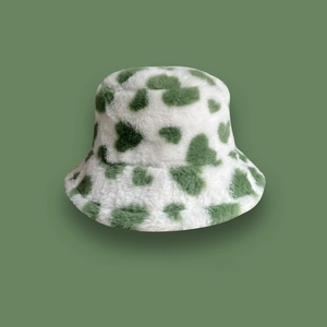 Plush faux fur bucket hat with green spotted pattern for winter warmth and style