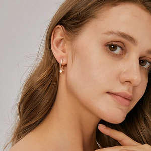 U-shaped gold plated brass earrings with micro-inlaid zircon worn by a model