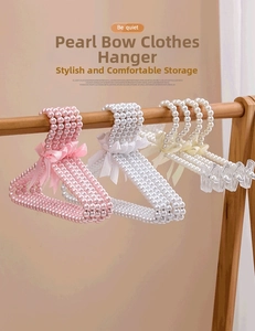 Detail of luxury pearl hangers with silk bows and clips for children and pet clothes
