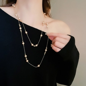 Vue détaillée du collier double rang avec perles champagne et cristaux sur un mannequin